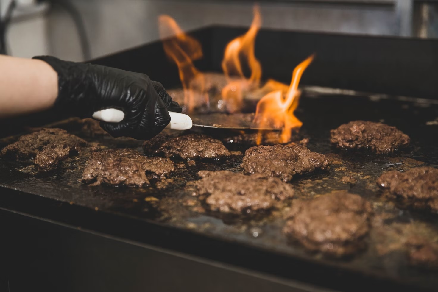 Beef patties cooking on grill